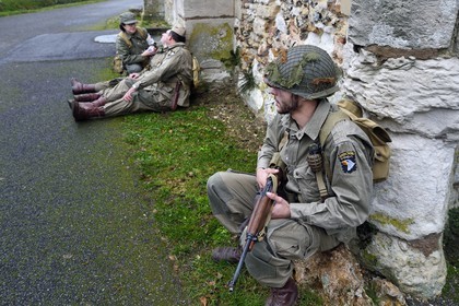 France, Eure, Chambray, Allied Reconstitution Group (US World War 2 and french Maquis historical reconstruction Association), reenactors in uniform of the 101st US Airborne Division resting in front of the church