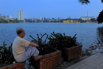 Vietnam, Hanoi, old man looking at Truc Bach lake