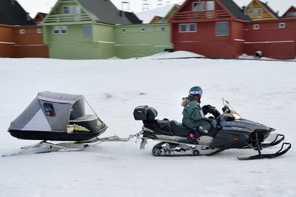 Norvège, Svalbard, Spitzberg, Longyearbyen, motoneige avec les enfants dans la remorque fermée