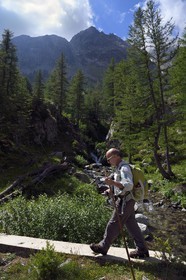 France, Alpes-Maritimes (06), parc national du Mercantour, vallée de la rivière Valmasque et sommets de la haute Valmasque, le guide et ancien garde-moniteur du parc Alain Lanteri-Minet sur le pont qui franchit le torrent de la Valmasque