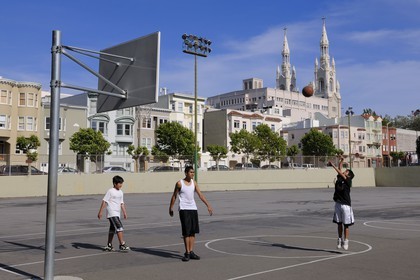 Etats-Unis, Californie, San Francisco, terrain de basket à l'angle de Powell street et Lombard street dans le quartier de North Beach et les flèches de l'église Sts Peter and Paul church