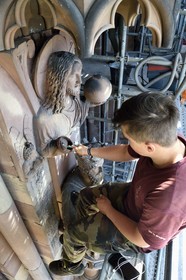 France, Bas-Rhin (67), Strasbourg, vieille ville classée au Patrimoine Mondial de l'UNESCO, la cathédrale Notre-Dame, chantier de restauration du Portail du Jour du jugement, Christ redempteur au dessus du Roi Salomon, nettoyage de la sculture à la brosse à dent par un apprenti tailleur de pierre