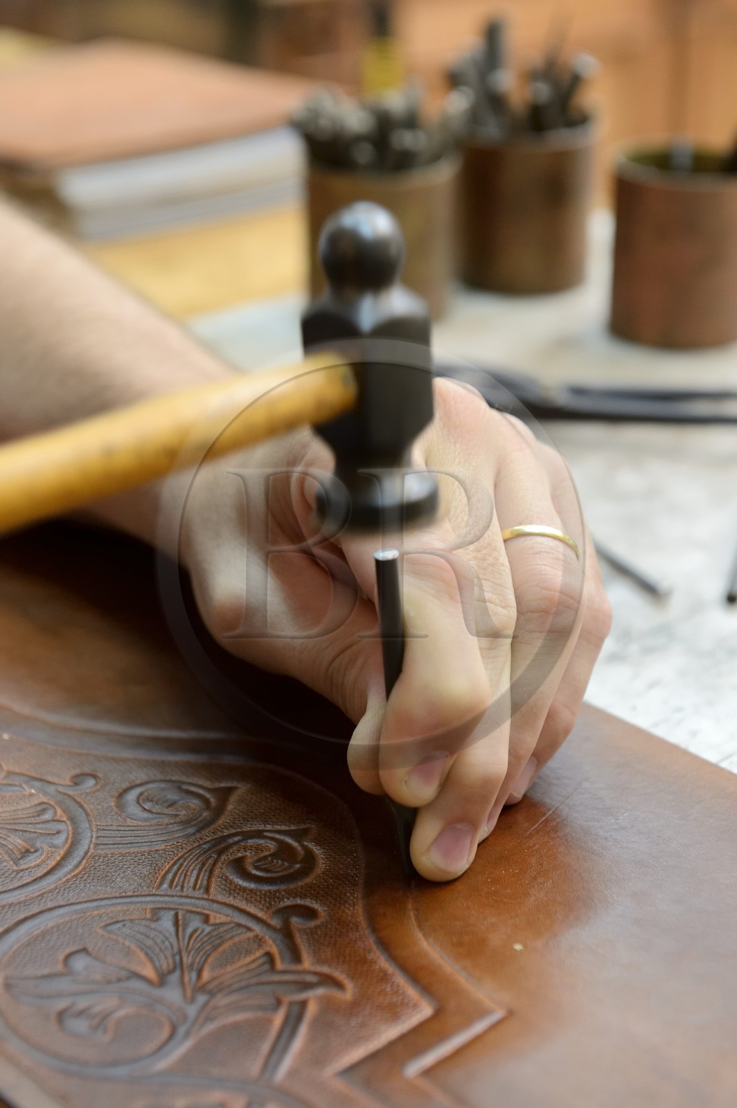 Argentina, Buenos Aires Province, San Antonio de Areco, workshop of the leather craftsman Martin Alvarez hammering the leather of a saddle piece