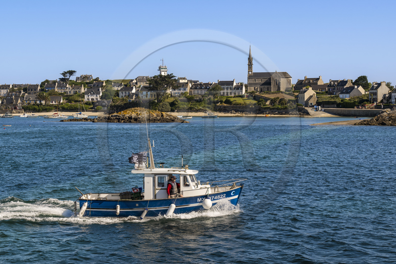 France, Finistère, Ponant Islands, Ile de Batz (Batz Island), boat going fishing and the Notre-Dame-du-Bon-Secours church in the Bourg