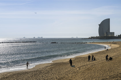 Spain, Catalonia, Barcelona, La Barceloneta, the beach and the Hotel W Barcelona by architect Ricardo Bofill on the seafront in the background