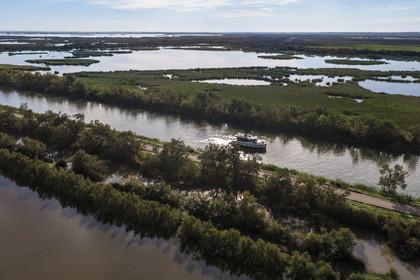 France, Gard (30), la Petite Camargue, navigation d'un bateau de plaisance Le Boat sur le canal du Rhône à Sète entre Gallician et Aigues-Mortes (vue aérienne) France, Gard, the Petite Camargue, navigation of a pleasure boat Le Boat on the Rhone to Sète Canal between Gallician and Aigues-Mortes (aerial view)
