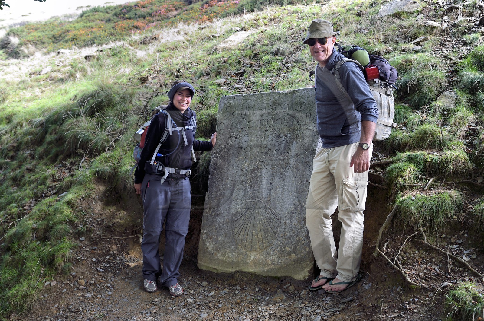 France, Pyrenees Atlantiques, Basque Country, Camino de Santiago (the Way of St. James) on the GR 65 between Saint Jean Pied de Port and Roncesvalles towards the Bentarte Pass, pilgrims in front of the stele indicating that Compostela is still 765 km