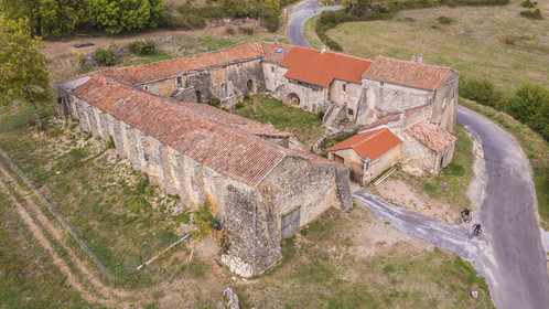 France, Aveyron (12), parc naturel régional des Grands-Causses, cyclistes effectuant l'itinéraire cyclo touristique Brebis'Cyclette en Pays de Roquefort, Ferme de Mascourbe qui appartenait à la commanderie des Hospitaliers de Saint-Jean de Jérusalem (vue aérienne)
