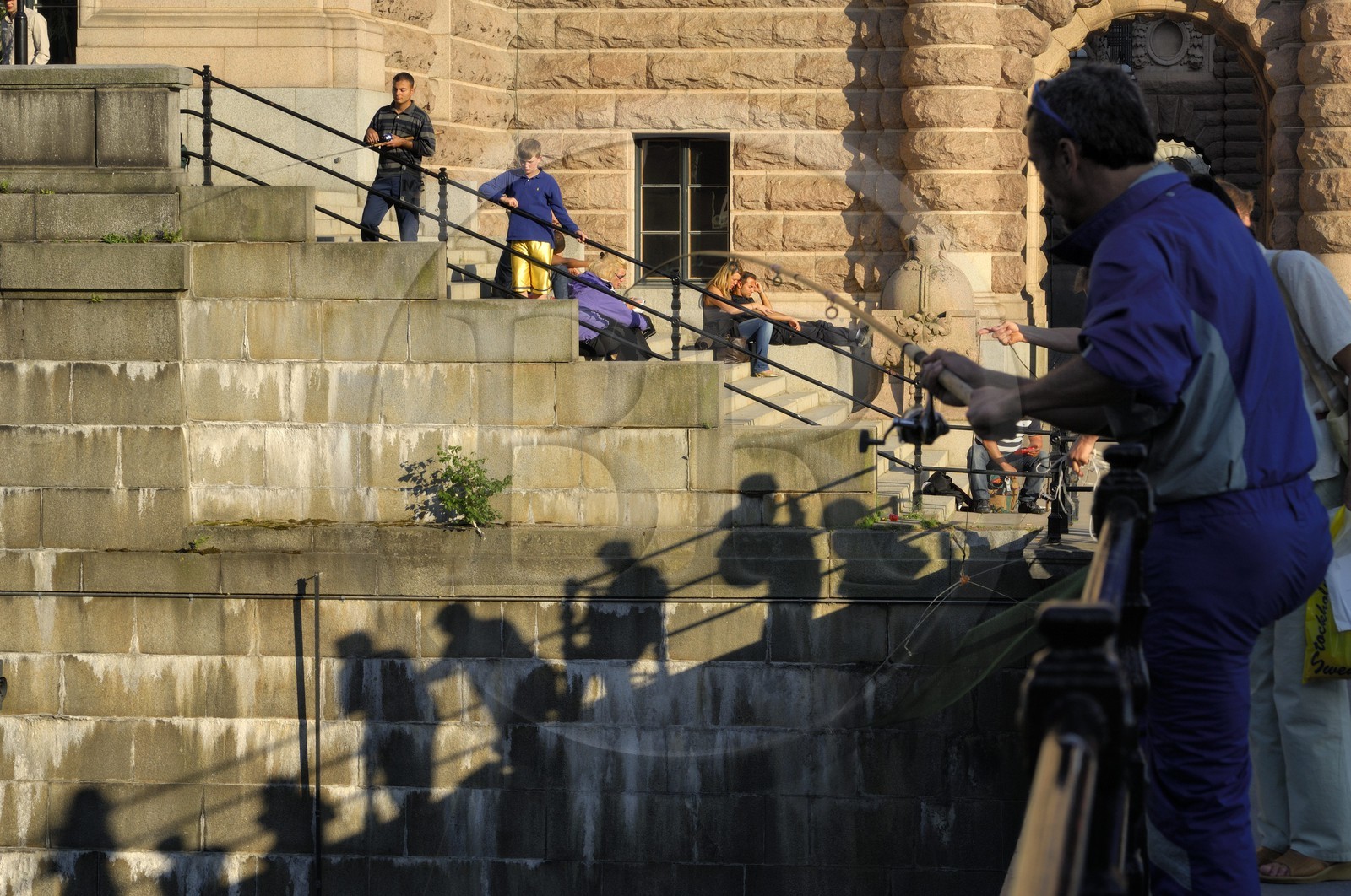 Suède, Stockholm, île de Gamla Stan (vieille ville), pêcheurs sur les quais en bordure de la rue Riksgatan