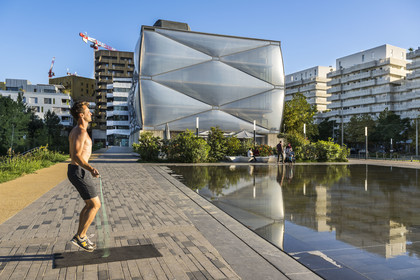 France, Hérault (34), Montpellier,  quartier de Port Marianne, batiment le Nuage réalisation du créateur Philippe Starck, sportif à la corde à sauter devant le miroir d'eau au premier plan sur l'avenue Raymond Dugrand