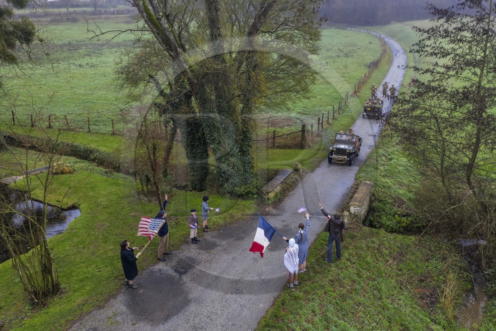 France, Eure (27), Sainte-Colombe-prés-Vernon, Allied Reconstitution Group (association de reconstitution historique de la 2éme Guerre Mondiale américain et Maquis), reconstitueurs en uniforme de la 101e division aéroportée US progressant en jeep Willys accueillis en libérateurs par des villageois et FFI (vue aérienne)