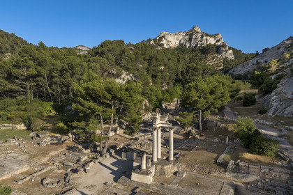 France, Bouches-du-Rhône (13), Parc Naturel Régional des Alpilles, Saint-Rémy-de-Provence, site archéologique de Glanum au pied du massif des Alpilles, colonnes et entablement reconstitués du petit temple géminé du premier forum au premier plan (vue aérienne)