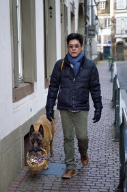 France, Bas Rhin, Strasbourg, dog carrying the purchases of his master
