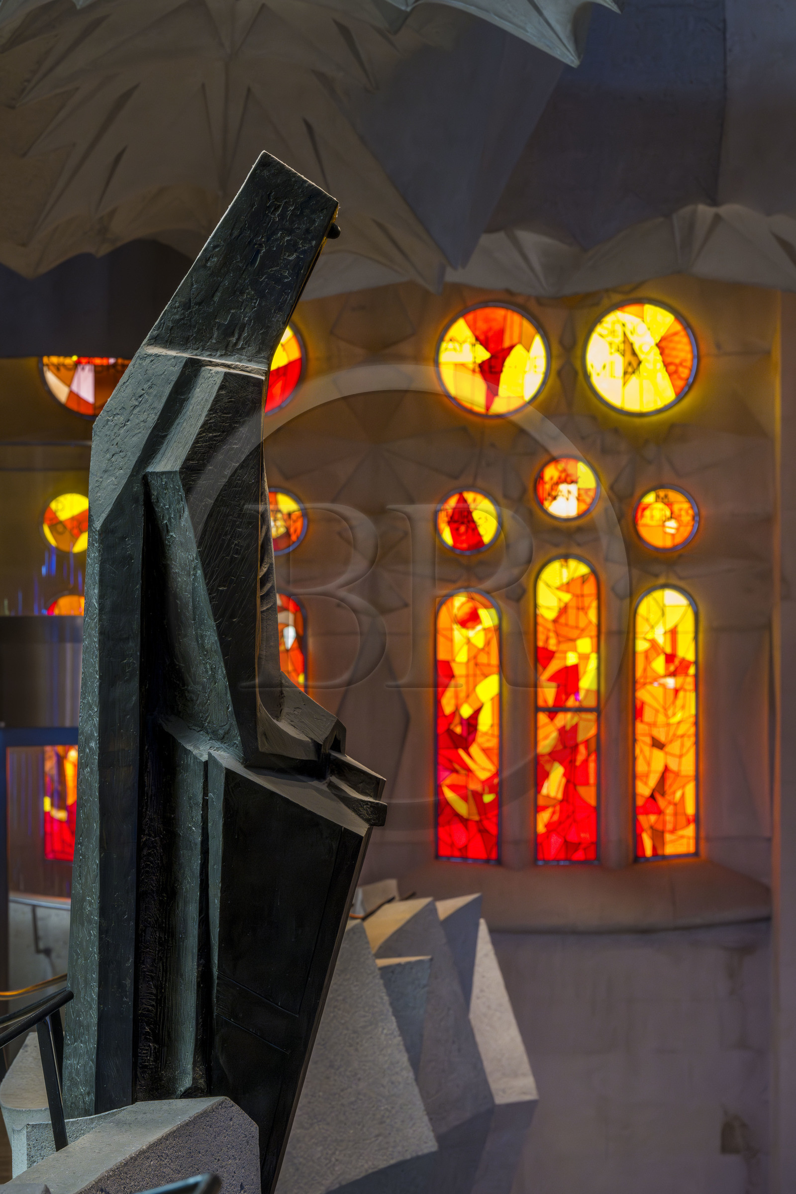 Espagne, Catalogne, Barcelone, quartier de l'Eixample, basilique de la Sagrada Familia de l'architecte du modernisme catalan Antoni Gaudi classée Patrimoine Mondial de l'UNESCO, statue en bronze de Saint Georges (Sant Jordi) par le sculpteur Subirachs au centre de l'intérieur de la facade de la Gloire et le côté facade de la Passion de la Nef aux vitraux aux couleurs chaudes