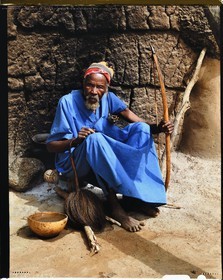 Burkina Faso, Poni province, Lobi land, Loropéni region, head of the village of Ouadara posing with its attributes (bow and arrows, fly swatter) and a calabash of millet (cereal) beer