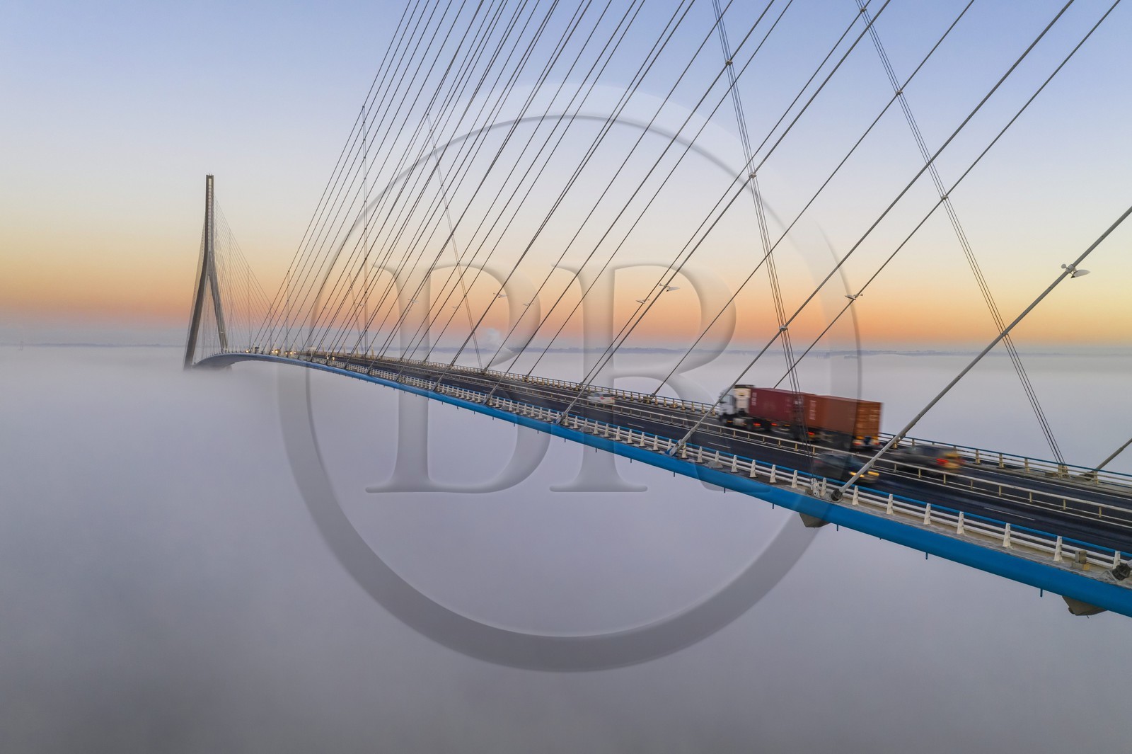 France, entre Calvados (14) et Seine-Maritime (76), le Pont de Normandie émerge des brumes matinales de l'automne et enjambe la Seine pour relier les villes de Honfleur et du Havre