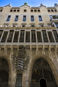 Espagne, Catalogne, Barcelone, le Palais Güell (Palau Güell) construit entre 1886 et 1891 et réalisé par l'architecte du modernisme catalan Antoni Gaudi, site classé au Patrimoine Mondial de l'UNESCO, le blason entre les portes cochères évoque le drapeau catalan et le phénix qui le surmonte symbolise la renaissance de la littérature catalane