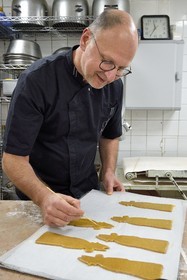France, Meurthe-et-Moselle (54), Nancy, le patissier Didier Hulot à la fabrication du pain d'épice de la Saint-Nicolas, dessin sur la pâte déjà en forme