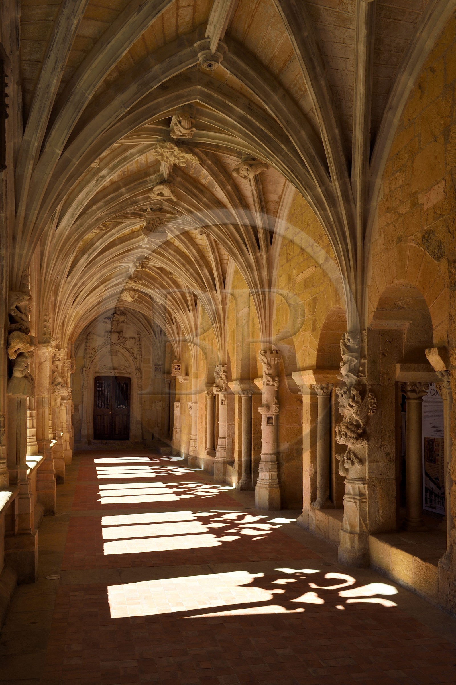 France, Dordogne,  Perigord Noir, Le Buisson de Cadouin, former cistercian abbey church, stage on the Camino de Santiago (Way of St. James) listed as World Heritage by UNESCO, the cloister of the 15th century, entrance to the chapter house right and the Royal Door in the background