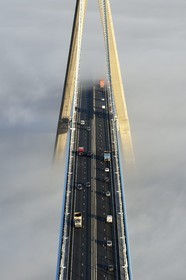 France, entre Calvados (14) et Seine-Maritime (76), le Pont de Normandie qui émerge des brumes matinales de l'automne et enjambe la Seine, vue depuis le sommet du pylone sud