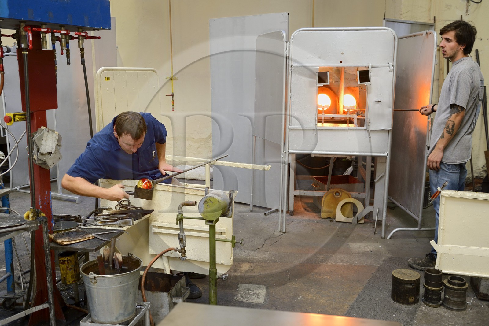 France, Moselle (57), Saint-Louis-les-Bitche, la Cristallerie Saint-Louis, souffleur qui s'aide d'une mailloche en bois pour arrondir le verre et faire une boule presse-papiers en cristal régulière, une des nombreuses étapes de la réalisation d'une boule presse-papiers