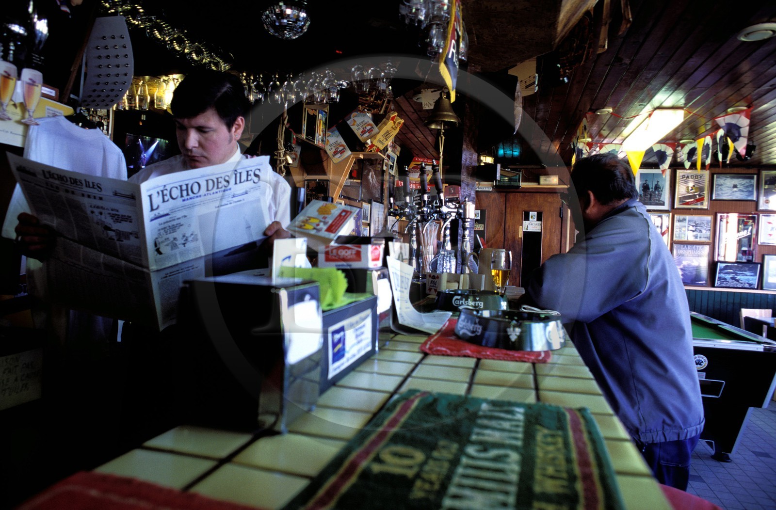 France, Finistere, Molene island, the owner of the only cafe reading the islands newspaper