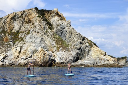 France, Var (83), Six-Fours-les-Plages, Ile des Embiez, Pointe du Coucoussa surplombée par la Tour de la Marine, le champion de windsurf Freestyle Adrien Bosson en randonnée aquatique sur un paddle