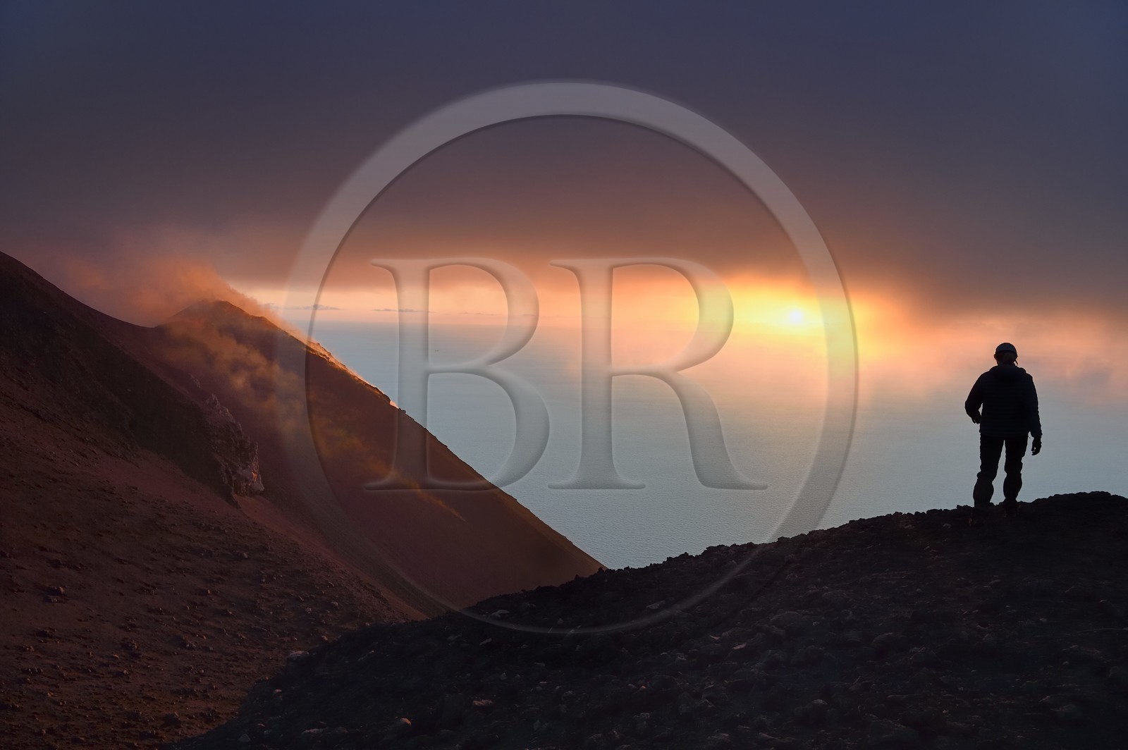 Italy, Sicily, Aeolian Islands, listed as World Heritage by UNESCO, Stromboli island, hiker watching the fumaroles of an eruption on the slopes of the active volcano at sunset