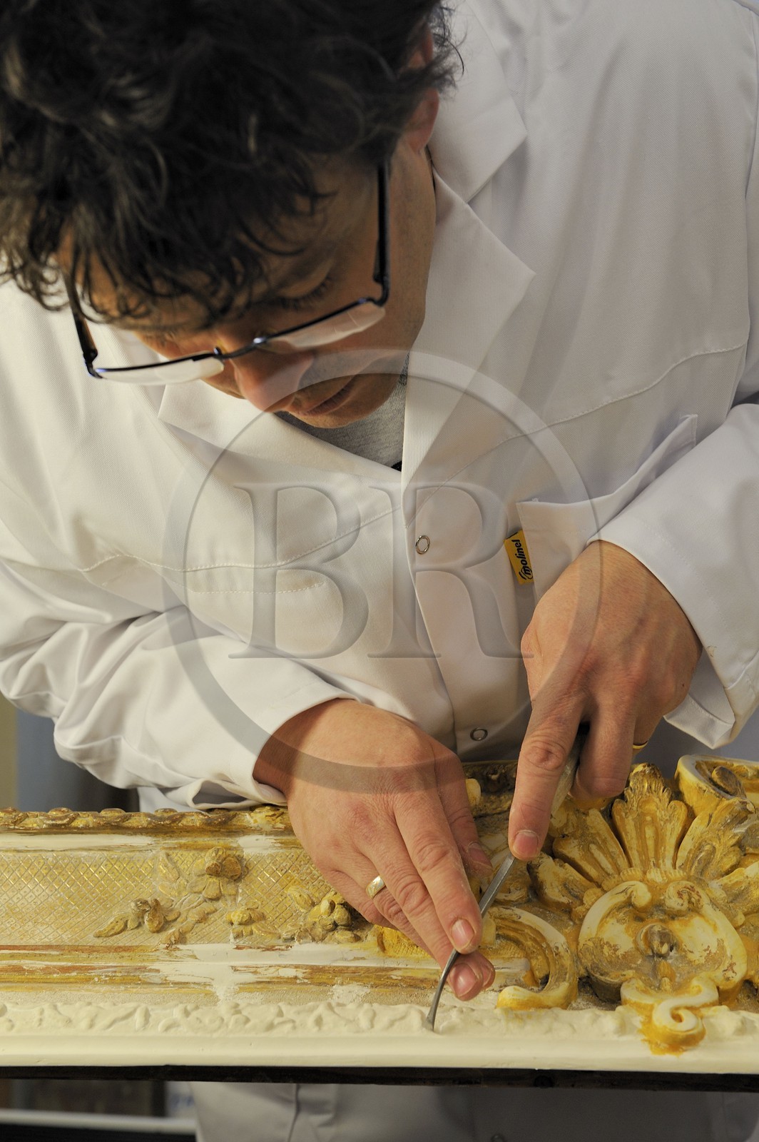 France, Yvelines, Chateau de Versailles, the castle restoration workshop, gilt workshop, Laurent Hissier working on a frame