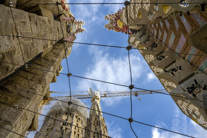 Espagne, Catalogne, Barcelone, quartier de l'Eixample, basilique de la Sagrada Familia de l'architecte du modernisme catalan Antoni Gaudi classée Patrimoine Mondial de l'UNESCO, un des quatre campaniles de 135m entourant le ciborium central et la future tour centrale, son pinacle est couronné par un homme ailé qui symbolise saint Matthieu, au premier plan les pinacles des tours de la façade de la Passion
