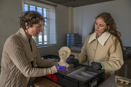 France, Saône-et-Loire (71), Autun, réserves du musée Rolin, la directrice des musées  Agathe Mathiaut-Legros et du patrimoine et la conservatrice adjointe Axelle Goupy manipulant une figurine en terre cuite gallo-romaine d'une nécropole