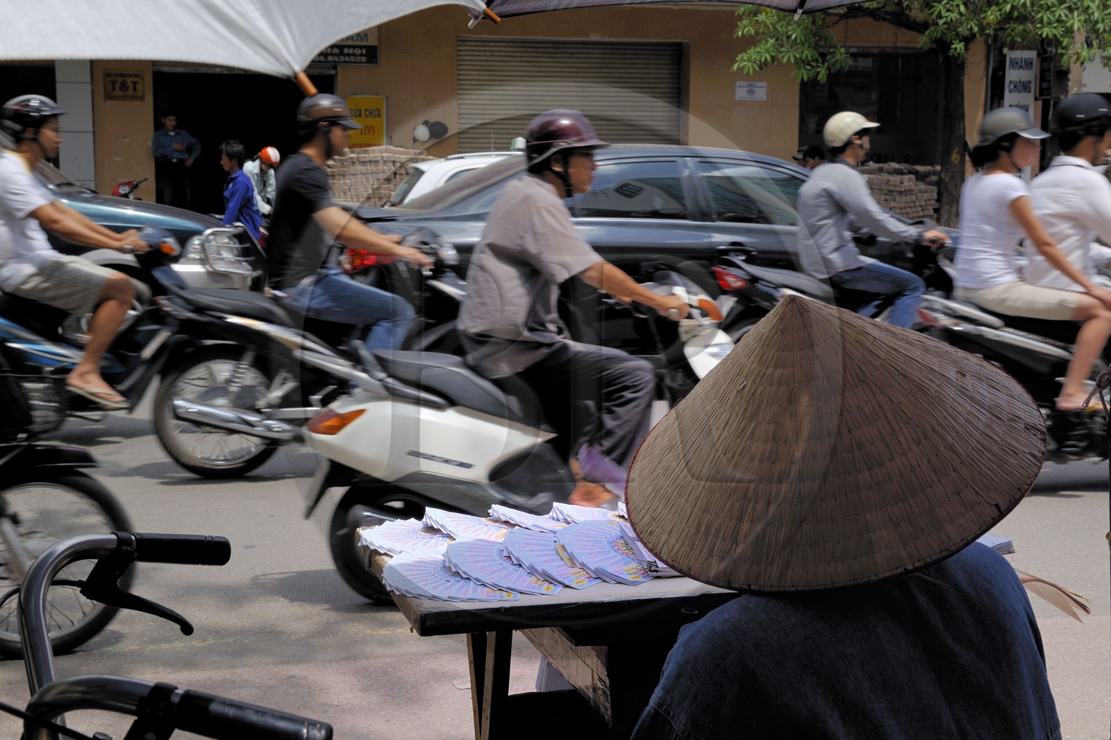 Vietnam, Hanoï, circulation en moto dans la vieille ville et vendeuse de tickets de loterie