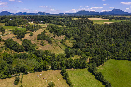 France, Puy-de-Dôme (63), la butte basaltique de Saint-Pierre-Le-Chastel surplombant la vallée de la Sioule, la Chaîne des Puys classée Patrimoine Mondial de l’UNESCO, avec le Puy de Côme à gauche, le Grand Suchet et le volcan Puy de Dôme à droite (vue aérienne)