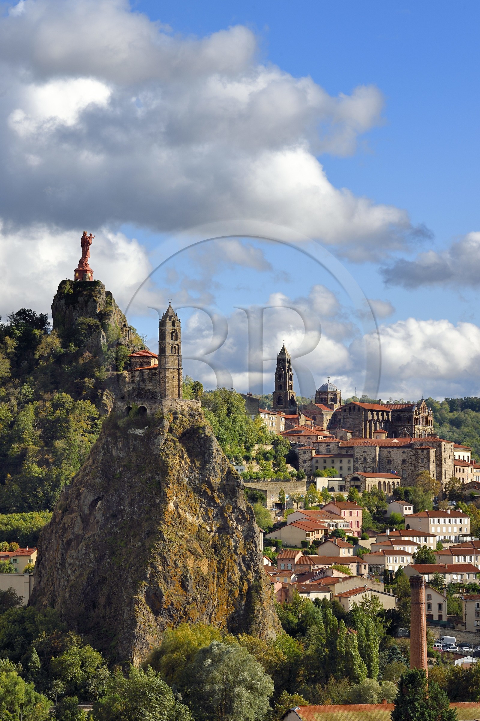 France, Haute Loire, Le Puy en Velay, Routes of Santiago de Compostela in France listed as World heritage by UNESCO, view of the city with the Saint-Michel d'Aiguilhe Chapel perched on a volcanic peak in the foreground, the Notre Dame de France statue (from 1860) on the Rocher Corneille overlooking the 12th century Notre Dame de l'Annonnement cathedral in the background