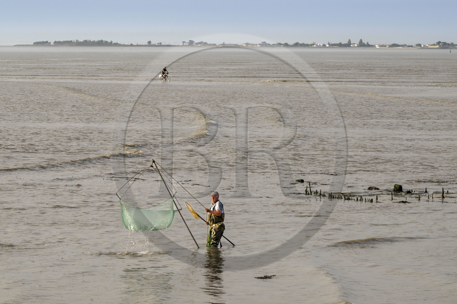 France, Charente-Maritime (17), Port-des-Barques, pêcheur au carrelet et cycliste empruntant le tombolo de la Passe aux Boeufs qui relie le continent à l'Ile Madame à marée montante en arrière plan