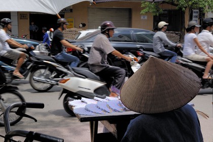 Vietnam, Hanoi, motorcycle traffic in the old city and lotery ticket seller