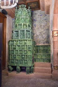 France, Bas Rhin, Orschwiller, Alsace Wine Road, Haut Koenigsbourg Castle, the arms room presents the various halberds, swords, crossbows and armors as well as the copy of an imposing green glazed ceramic stove with incorporated heated seat