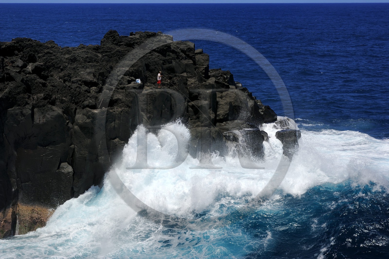 France, Reunion island (French overseas department), South coast, Saint Philippe, the Cap Mechant (Bad Cape) is located along a rugged coastline of volcanic rock hit by waves and typical of the area called Sud sauvage (Wild South), fisherman on a rock