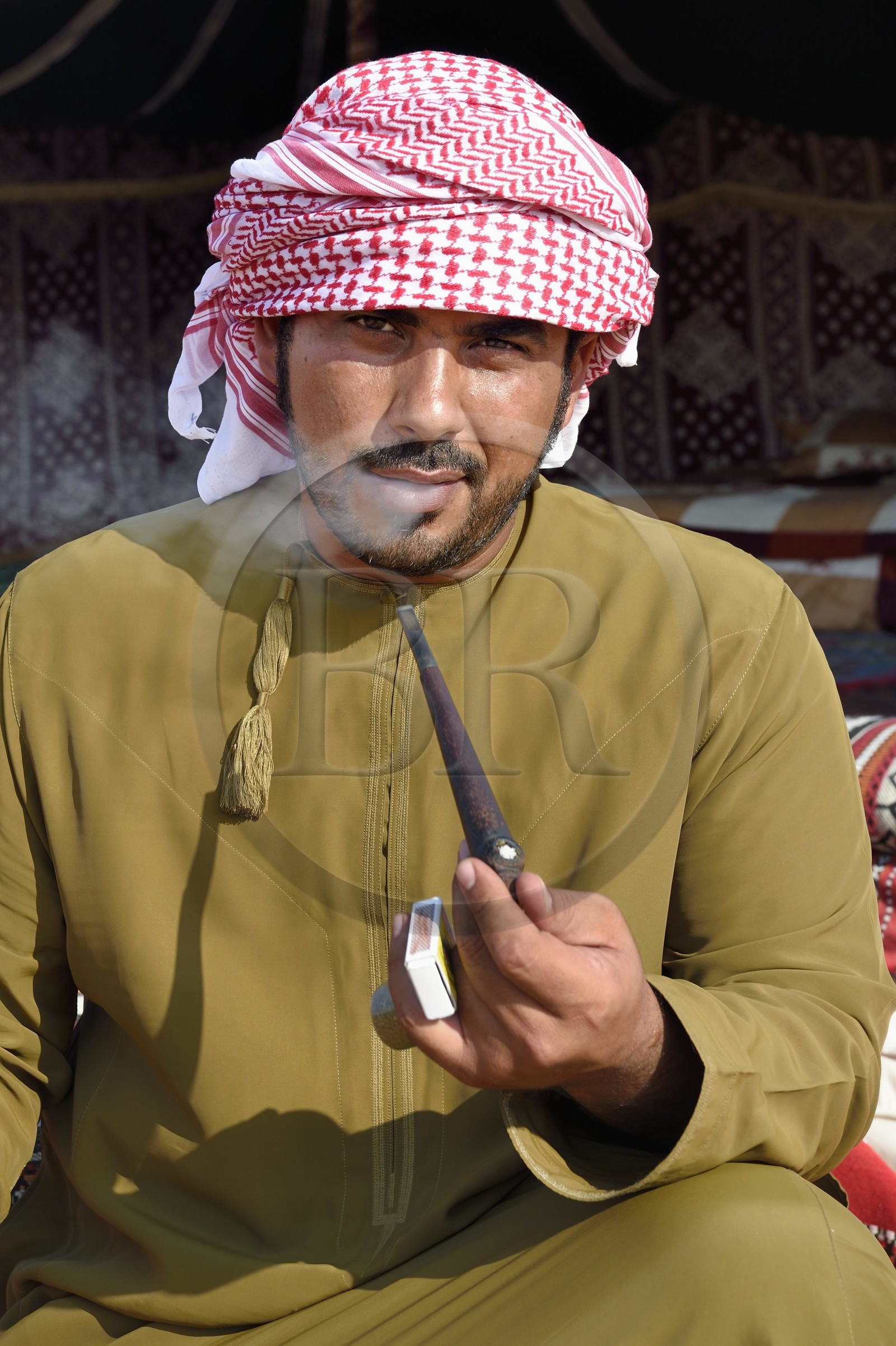 Sultanate of Oman, governorate of Ash Sharqiyah, desert of Wahiba Sands or Sharqiya Sands, Bedouin village of al-Wasil, Mohamed al-Badri fume la pipe devant sa tente