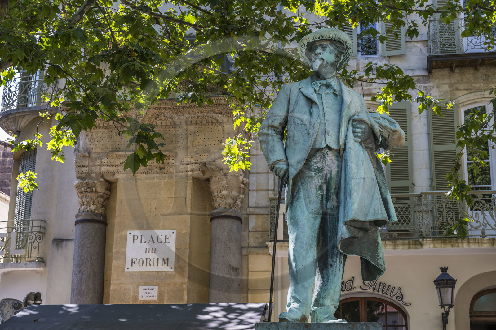 France, Bouches-du-Rhône (13), Arles, colonnes de Saint Lucien, demi-fronton et deux chapiteaux corinthiens, seuls vestiges d'un petit temple de l'antique forum romain sur l'actuelle place du Forum, classé Patrimoine Mondial de l'UNESCO, la statue de Frédéric Mistral écrivain provençal (1830-1914)