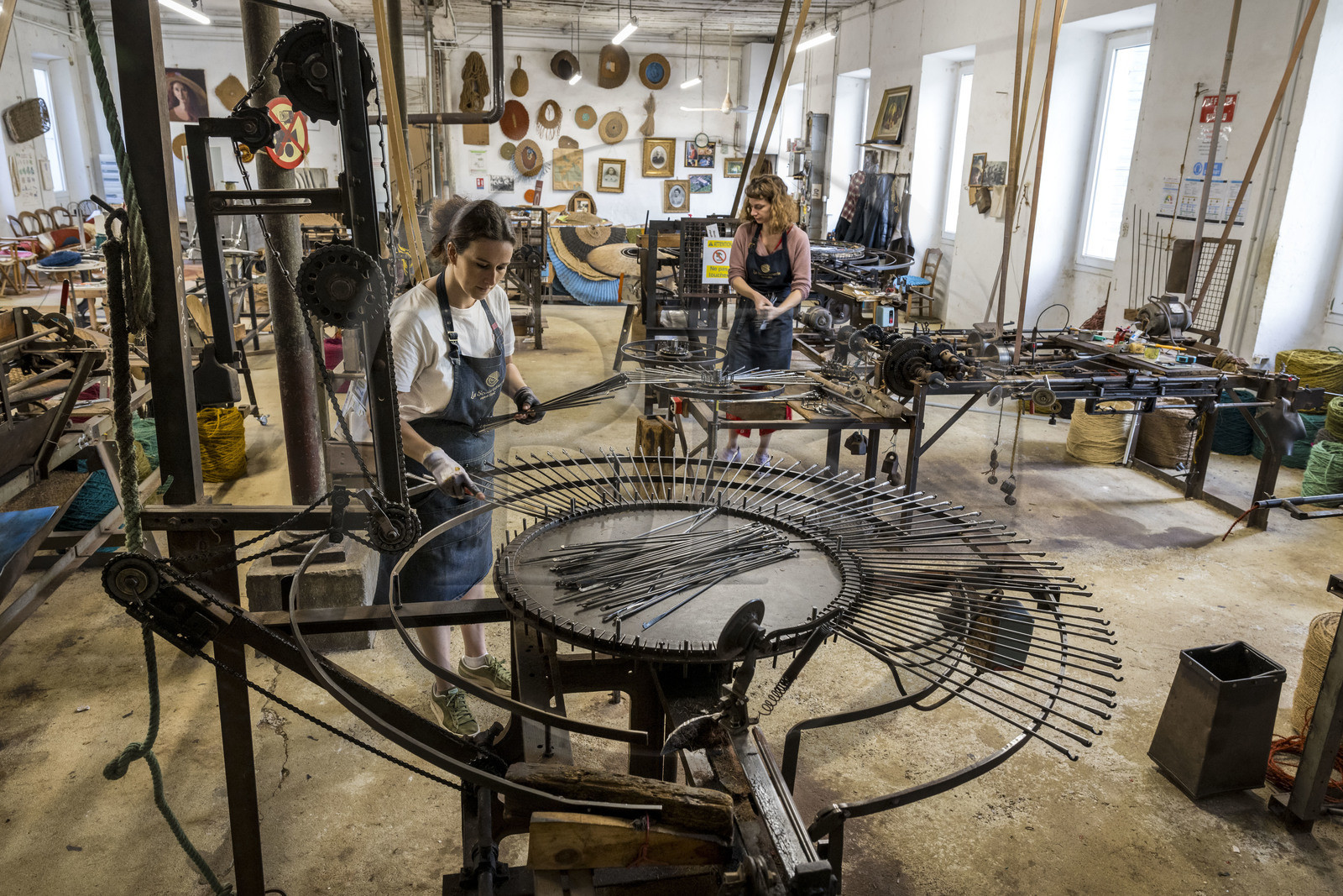 France, Drôme (26), Drôme provençale, Nyons, La Scourtinerie, dernière manufacture de scourtins de Provence, filtres traditionnels utilisés dans la fabrication de l'huile d'olive mais conçus aussi aujourd'hui comme objets de décoration en fibre de coco, fabrication de scourtins dans leur atelier, Sophie Villeneuve-Fert procède aux réglages d'une tisseuse-tireuse pour grands formats jusqu'à 2,5m de diamètre