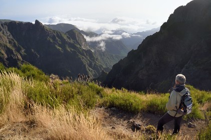 Portugal, Ile de Madère, randonnée sur le Vereda do Areeiro entre les monts Pico Ruivo (1862m) et Pico Arieiro (1817m), randonneuse contemplant la vallée de Faja da Nogueira