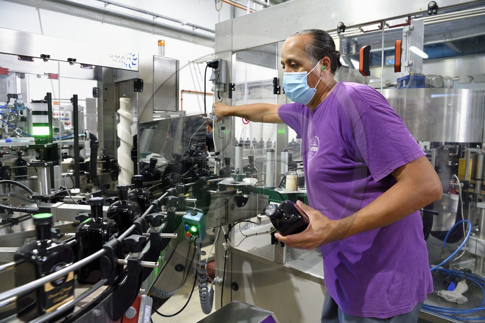 France, Ile de la Reunion, Saint Pierre, domaine de la distillerie Isautier, usine d'embouteillage et d'étiquetage, chaine de mise en bouteille de 70cl de rhum arrangé