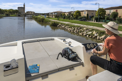 France, Gard (30), Aigues-Mortes, navigation d'un bateau de plaisance Le Boat sur le canal du Rhône à Sète, la Tour Constance et les remparts en arrière plan