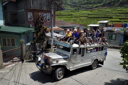 Philippines, province d'Ifugao, ville de Banaue, jeepney (jeep allongée pour le transport de passagers) dans la rue principale, passagers sur le toit