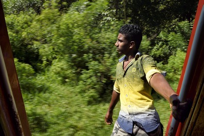 Sri Lanka, Province d'Uva, trajet en train dans la région montagneuse de la culture du thé entre Badulla et Ella, passager accroché aux portières
