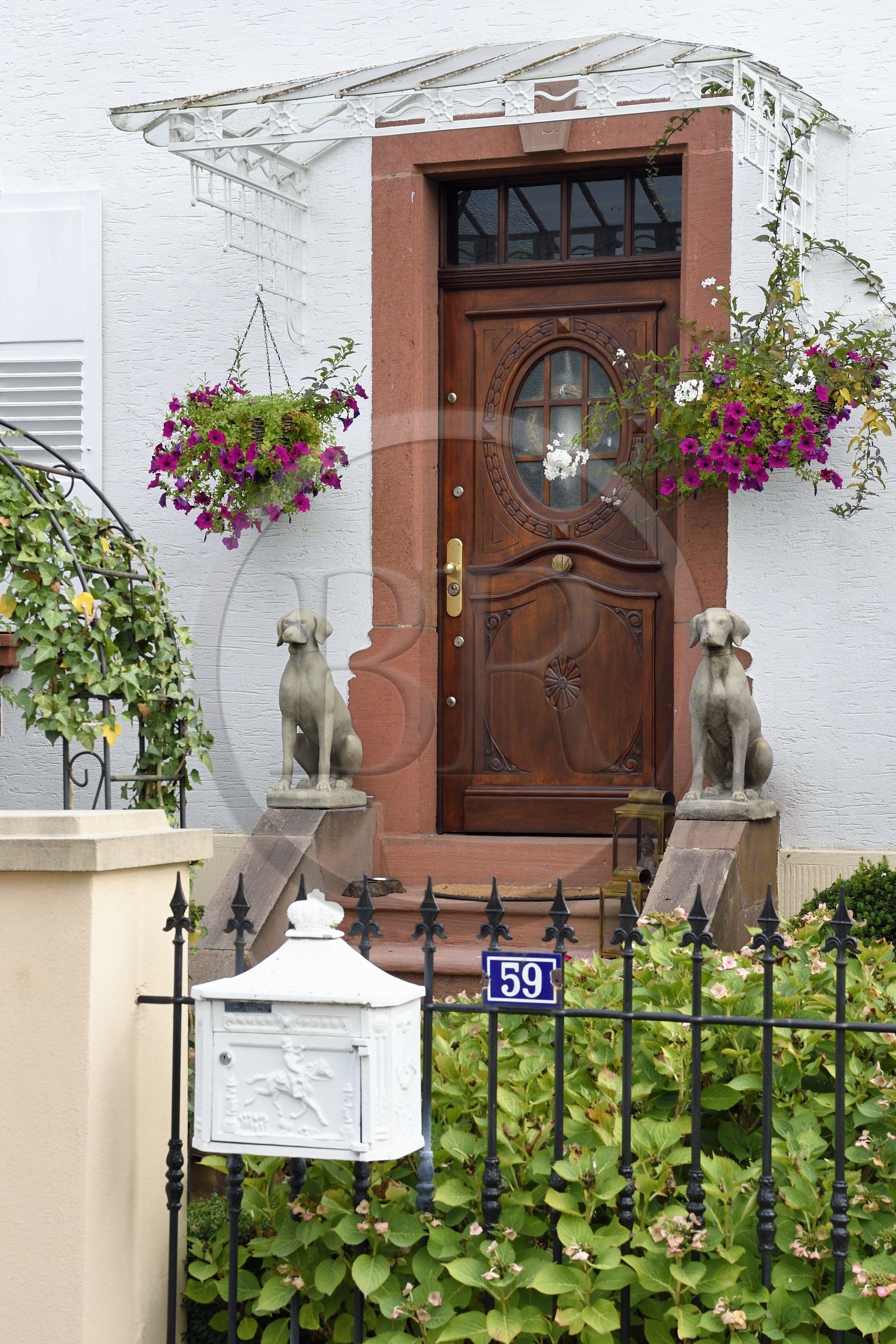 France, Bas-Rhin (67), Parc naturel régional des Vosges du Nord, Obersteinbach, chiens de garde en statues devant une maison