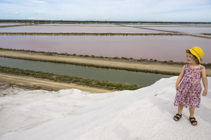 France, Gard, Aigues Mortes, the saline of Aigues-Mortes (Salins du Midi), little girl visiting on top of a salt mountain