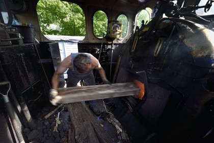 France, Alpes-Maritimes (06), Puget Théniers, le Train des Pignes, locomotive en chauffe, chargement du bois dans le geulard du foyer qui chauffe la chaudière