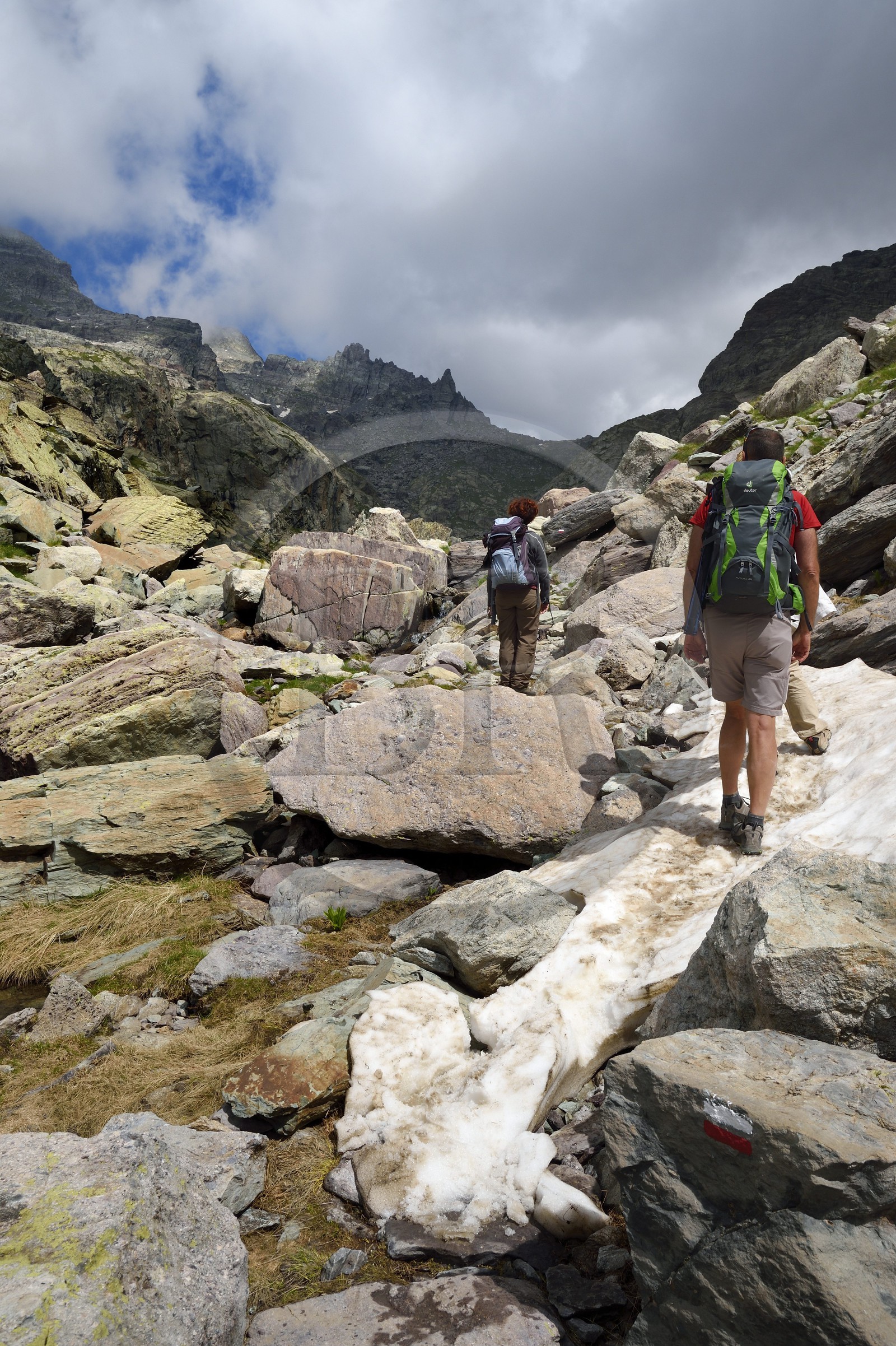 France, Alpes-Maritimes, parc national du Mercantour (Mercantour National Park), the Vallee des Merveilles (Valley of Wonders) scattered with thousands of rupestral engravings of the Bronze Age, hikers on the trail GR 52 towards the Baisse (pass) de Valmasque and the Mont Grand Capelet (2915 m) in the background